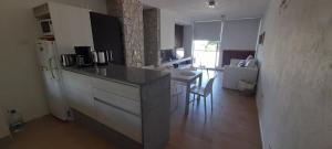 a kitchen with a counter and a kitchen with a refrigerator at Apartmento, Punta 30 Complejo in Mar Azul