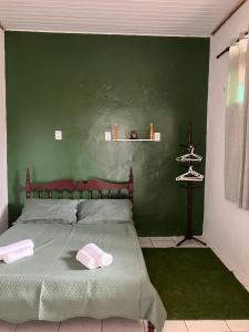 a green bedroom with a bed and a green wall at Quarto aconchegante no centro in São Luís