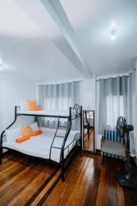 a bedroom with two bunk beds and a chair at Classic, Cozy House for Transient in Baguio City 1 in Baguio