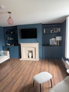 a living room with a blue wall with a fireplace at 4 bedroom house sleeps 8 next to Aviva Stadium and Landsdown Stadium in Dublin