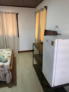 HuacasCabina Entre Playas的客房设有一张床、一张书桌和一台冰箱