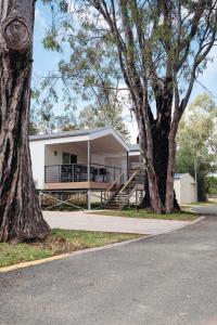 a white building with trees in front of it at Bridgewater Caravan Park Near Bendigo in Bridgewater-on-Loddon