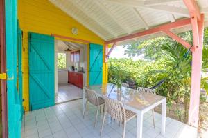 a colorful house with a table and chairs on a patio at Cas'à Willy in Sainte-Rose