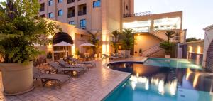 un hotel con piscina e sedie e un edificio di Flat JK Luxo a Ribeirão Preto