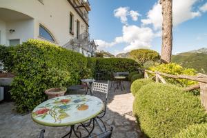 a patio with a table and chairs and a fence at La Dolce Vita Ravello - Exclusive Family & Group Villa with 4 Apartments, 5 Bedrooms in Ravello