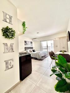 a bedroom with a bed and a living room at Loft natural - Zona rio - Turismo! in Rosario