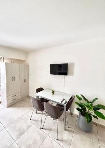 a white room with a table and chairs and a tv at Loft natural - Zona rio - Turismo! in Rosario