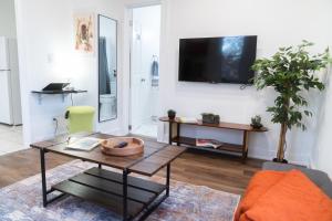un soggiorno con un tavolo e una TV su una parete di EconoPod 6 a River Rouge