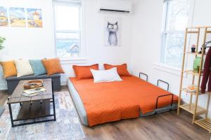 una camera da letto con un letto arancione e un divano di EconoPod 6 a River Rouge