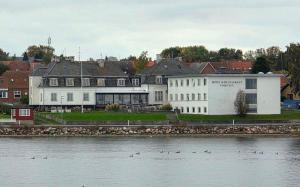 马斯塔尔Hotel Udsigten Marstal的水域旁边的一座白色大楼