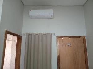 baño con calentador y cortina de ducha en Apartamento Confortável Novo com Ar condicionado, en Tangará da Serra