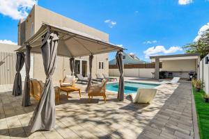 eine Terrasse mit einem Baldachin und Stühlen sowie einem Pool in der Unterkunft Monserat 33Q in Palm-Eagle Beach