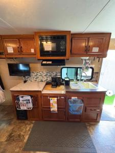 a kitchen with a sink and a microwave at ZenDen Rv by The Sea in Los Osos in San Luis Obispo