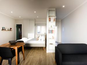 een slaapkamer met een bed, een tafel en een bank bij Casa Do Gato Das Sete Riscas in Óbidos