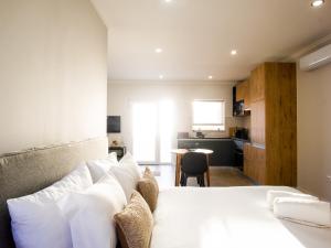 een slaapkamer met een wit bed en een keuken bij Casa Do Gato Das Sete Riscas in Óbidos