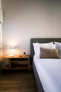 een slaapkamer met een bed en een nachtkastje met een lamp bij Casa Do Gato Das Sete Riscas in Óbidos