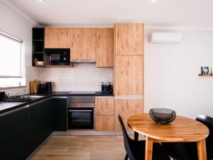 een keuken met houten kasten en een houten tafel bij Casa Do Gato Das Sete Riscas in Óbidos +24 foto's