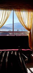 una camera da letto con una grande finestra con vista sull'oceano di Cabaña Nuestro Quincho a El Mollar