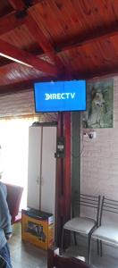 un cartello che dice "direct tv" in una stanza con sedie di Cabaña Nuestro Quincho a El Mollar