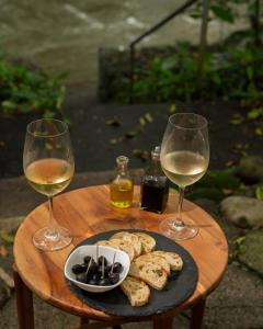 two glasses of wine and a plate of food on a table at La Pérgola lodge in Sarapiquí +48 photos