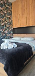 ein Schlafzimmer mit einem Bett mit drei Handtüchern darauf in der Unterkunft Pomorska Apartment in Breslau
