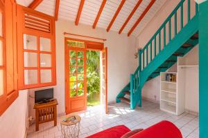 a living room with a staircase and a red couch at Cas'à Willy in Sainte-Rose