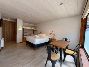 a bedroom with a bed and a table and chairs at Hotel Casa Surf in Pichilemu +2 photos