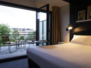 una camera d'albergo con un letto e un balcone di ibis Styles Dreux Centre Gare a Dreux Altre 113 foto