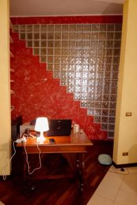 an office with a desk and a red wall at A un passo dal centro gli orsetti del duomo in Piacenza +2 photos