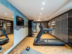 einen Fitnessraum mit Laufband und Trainingsgeräten in der Unterkunft Aparthotel Adagio access Hamburg in Hamburg