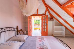a bedroom with a bed and an open door at Cas'à Willy in Sainte-Rose +85 photos