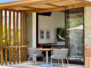 a patio with a table and chairs on a deck at Umbelina Pousada Boutique in Porto De Galinhas