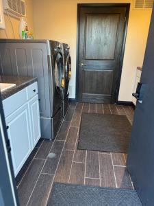 una cocina con lavadora y secadora junto a una puerta en The Melrose, en Sandusky