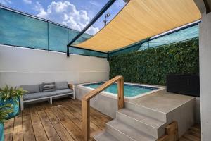 Ocean Park Studio Pool at Riviera Villa في سان خوان: فناء مع حوض استحمام ساخن وسلالم مع حوض سباحة