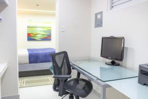 Ocean Park Studio Pool at Riviera Villa في سان خوان: مكتب مع جهاز كمبيوتر وكرسي في الغرفة