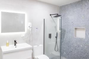 Ocean Park Studio Pool at Riviera Villa في سان خوان: حمام مع دش ومرحاض ومغسلة +صورة واحدة