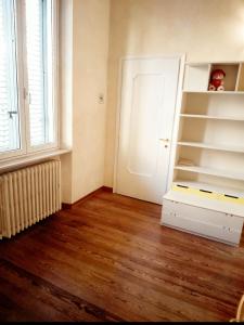 a room with a white book shelf and a door at A un passo dal centro gli orsetti del duomo in Piacenza