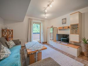 a living room with a couch and a tv at Gastl in Hopfgarten im Brixental