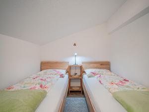two beds sitting next to each other in a room at Gastl in Hopfgarten im Brixental