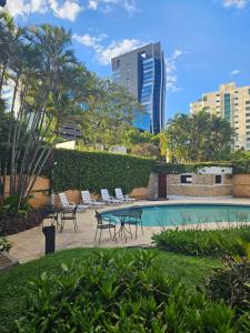 a pool with chairs and a table and a building at Green Palace Hotel Boutique in Asuncion