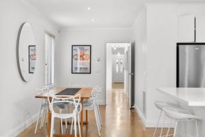 Geelong WestMia's Place Modern Pet friendly Geelong West stay的一间拥有白色墙壁和桌椅的用餐室 更多12张照片