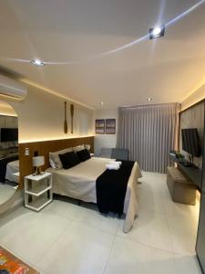 una camera d'albergo con un letto e una televisione di Flat Intermares a Cabedelo