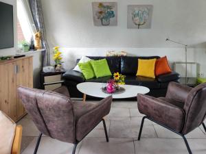 een woonkamer met een bank, een tafel en stoelen bij Moni in Hüttenrode