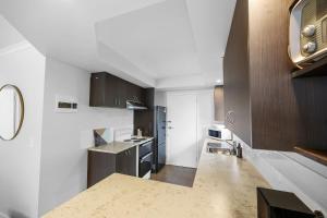 a kitchen with white walls and brown cabinets at Beach Retreat in Warrnambool