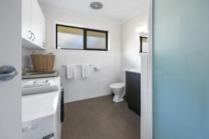 a white bathroom with a sink and a toilet at Beach Retreat in Warrnambool +11 photos