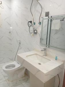 a white bathroom with a sink and a toilet at فندق الضيافة in Rawkhah +16 photos
