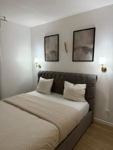 a bed in a bedroom with two pictures on the wall at Magnifique appartement 3 pièces à Vitry-sur-seine (15min de Paris) in Vitry-sur-Seine +30 photos