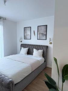 a bedroom with a bed with two pictures on the wall at Magnifique appartement 3 pièces à Vitry-sur-seine (15min de Paris) in Vitry-sur-Seine