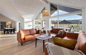 ein Wohnzimmer mit Sofas und einem Tisch in der Unterkunft Cozy Home In Glesborg With Sauna in Fjellerup