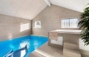 ein Badezimmer mit Swimmingpool und Badewanne in der Unterkunft Cozy Home In Glesborg With Sauna in Fjellerup
